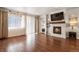 Bright living room with fireplace, hardwood floors, and natural light from large window at 9235 Quintero St, Commerce City, CO 80022