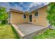 Backyard patio with a concrete slab and lawn leading to the yellow house at 3100 S Corona St, Englewood, CO 80113