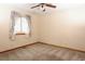 Empty bedroom features carpet, a window with floral curtains, and a ceiling fan at 3100 S Corona St, Englewood, CO 80113