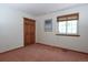 This bedroom has a window and closet with neutral carpet and paint at 3100 S Corona St, Englewood, CO 80113