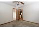 Spacious bedroom with neutral carpet, ceiling fan, and two open doorways at 3100 S Corona St, Englewood, CO 80113