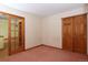 Empty bedroom showcasing a door to another room and large closet with paneled doors at 3100 S Corona St, Englewood, CO 80113