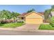 Inviting yellow home featuring a spacious two-car garage and a well-manicured front lawn at 3100 S Corona St, Englewood, CO 80113