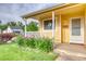 Inviting front porch with lovely flower beds and a bright yellow exterior at 3100 S Corona St, Englewood, CO 80113
