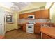 Functional kitchen featuring white appliances, wood cabinets, and tile flooring at 3100 S Corona St, Englewood, CO 80113