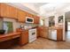 Functional kitchen featuring a white gas range, light wood cabinets, and stainless steel dishwasher at 3100 S Corona St, Englewood, CO 80113