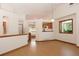 Sunlit living area with hardwood floors, a view to the kitchen, and bright, neutral walls at 3100 S Corona St, Englewood, CO 80113
