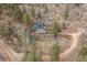 Aerial view of a home nestled among trees with a long drive and lush surroundings at 1264 Beaver Brook Canyon Rd, Evergreen, CO 80439