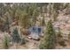 Aerial view of mountain home with wooded surroundings, unique architecture, and private setting at 1264 Beaver Brook Canyon Rd, Evergreen, CO 80439