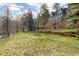 Lush backyard with stone fireplace, deck, and plenty of space for outdoor activities at 1264 Beaver Brook Canyon Rd, Evergreen, CO 80439