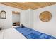 Bright bedroom with wooden ceilings and fresh blue linen atop a cozy queen size bed at 1264 Beaver Brook Canyon Rd, Evergreen, CO 80439