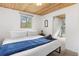 Cozy bedroom with comfortable bed, soft blanket, and natural light from window at 1264 Beaver Brook Canyon Rd, Evergreen, CO 80439