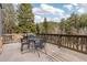 Wooden deck with forest views, a patio set, and a grill is an entertainer's dream at 1264 Beaver Brook Canyon Rd, Evergreen, CO 80439