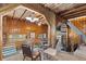 Inviting dining area with wood-paneled walls and ceilings, modern lighting, and glass-top dining table at 1264 Beaver Brook Canyon Rd, Evergreen, CO 80439