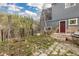 Home exterior with stone accents, a red door, and steps to a lush yard at 1264 Beaver Brook Canyon Rd, Evergreen, CO 80439