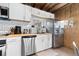 Well-lit kitchen featuring white cabinetry, stainless steel appliances, and modern butcher block countertops at 1264 Beaver Brook Canyon Rd, Evergreen, CO 80439