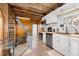 Bright kitchen with stainless steel appliances, light countertops, white cabinets, and unique wood accents at 1264 Beaver Brook Canyon Rd, Evergreen, CO 80439