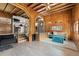 Spacious open-concept living area with wood-paneled walls, hardwood floors, and seamless transition to kitchen at 1264 Beaver Brook Canyon Rd, Evergreen, CO 80439