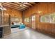Cozy living room with wood paneled walls, seating and soft rug at 1264 Beaver Brook Canyon Rd, Evergreen, CO 80439