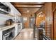 Comfortable living area with wood-paneled walls and ceilings, and staircase access to a modern kitchen at 1264 Beaver Brook Canyon Rd, Evergreen, CO 80439