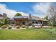 Backyard view featuring a covered patio, lush lawn, manicured landscaping, and solar panels at 1152 Clubhouse Dr, Broomfield, CO 80020