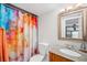 Stylish bathroom featuring a colorful shower curtain, granite vanity, and ample lighting at 1152 Clubhouse Dr, Broomfield, CO 80020