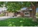 Charming brick home with a well-manicured lawn, mature tree, and attached three-car garage at 1152 Clubhouse Dr, Broomfield, CO 80020