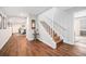 Inviting hallway with wood floors, white staircase, and an arched entrance to the dining room at 1152 Clubhouse Dr, Broomfield, CO 80020