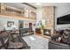 Cozy living room featuring a vaulted ceiling, stone fireplace, and comfortable leather seating at 1152 Clubhouse Dr, Broomfield, CO 80020