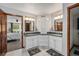 Modern main bathroom featuring double sinks, granite countertops, white cabinetry, and bedroom view at 1152 Clubhouse Dr, Broomfield, CO 80020