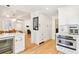 Bright kitchen with white cabinets, stainless appliances, breakfast bar, and an open concept to living space at 428 N Humboldt St, Denver, CO 80218
