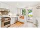 Bright kitchen with white cabinets, tile backsplash, stainless appliances, and a copper farmhouse sink at 428 N Humboldt St, Denver, CO 80218