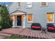 Up close view of the home's porch with brick flooring, seating, and warm lighting at 428 N Humboldt St, Denver, CO 80218