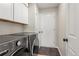 Functional laundry room with modern washer and dryer units and built-in storage cabinets at 9236 Vrain Ct, Westminster, CO 80031