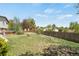 Spacious yard with garden beds, fire pit, mature trees, and fenced for privacy at 330 Johnson Dr, Castle Rock, CO 80104