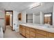 Bathroom featuring double sinks with wood cabinetry, a large mirror, and adjacent toilet and bath area at 330 Johnson Dr, Castle Rock, CO 80104