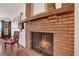Living room brick fireplace with wooden mantle and hearth, plus view of guitar and chair at 330 Johnson Dr, Castle Rock, CO 80104