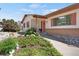 Inviting ranch-style home with a concrete walkway, gravel accents, and lush garden beds leading to the front door at 330 Johnson Dr, Castle Rock, CO 80104