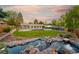 Beautiful backyard featuring a large deck, pond, lush lawn, and mature trees at 6013 S Logan St, Centennial, CO 80121