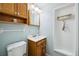 Small bathroom with wood cabinets and modern lighting fixtures at 6013 S Logan St, Centennial, CO 80121