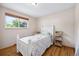 Bright bedroom featuring wood floors, white trim, neutral walls, and a cozy white bed at 6013 S Logan St, Centennial, CO 80121