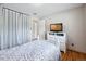 Cozy bedroom with light walls, a tv, white dresser, closet, and white trim at 6013 S Logan St, Centennial, CO 80121