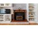 A brick fireplace with wood trim and white built-in shelves is perfect for a cozy living room at 6013 S Logan St, Centennial, CO 80121