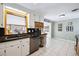 Well-lit kitchen with white cabinets, black granite countertops, and stainless steel appliances at 6013 S Logan St, Centennial, CO 80121
