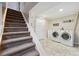 Bright laundry room with side-by-side washer and dryer conveniently located near stairs at 6013 S Logan St, Centennial, CO 80121