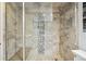 Updated shower with stone tile, glass door, rainfall showerhead, and bench at 6013 S Logan St, Centennial, CO 80121