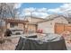 Backyard with pergola, hot tub, seating area, fire pit, and decorative rock waterfall feature at 4314 Nepal St, Denver, CO 80249