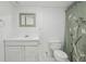 Bathroom features a white vanity with framed mirror and shower with decorative floral curtain at 4314 Nepal St, Denver, CO 80249