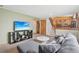 Inviting living room with stairs, a plush gray sofa, and a large TV at 4314 Nepal St, Denver, CO 80249