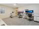 Basement home office area featuring two desks, computer setups, exercise equipment and carpeting at 4314 Nepal St, Denver, CO 80249